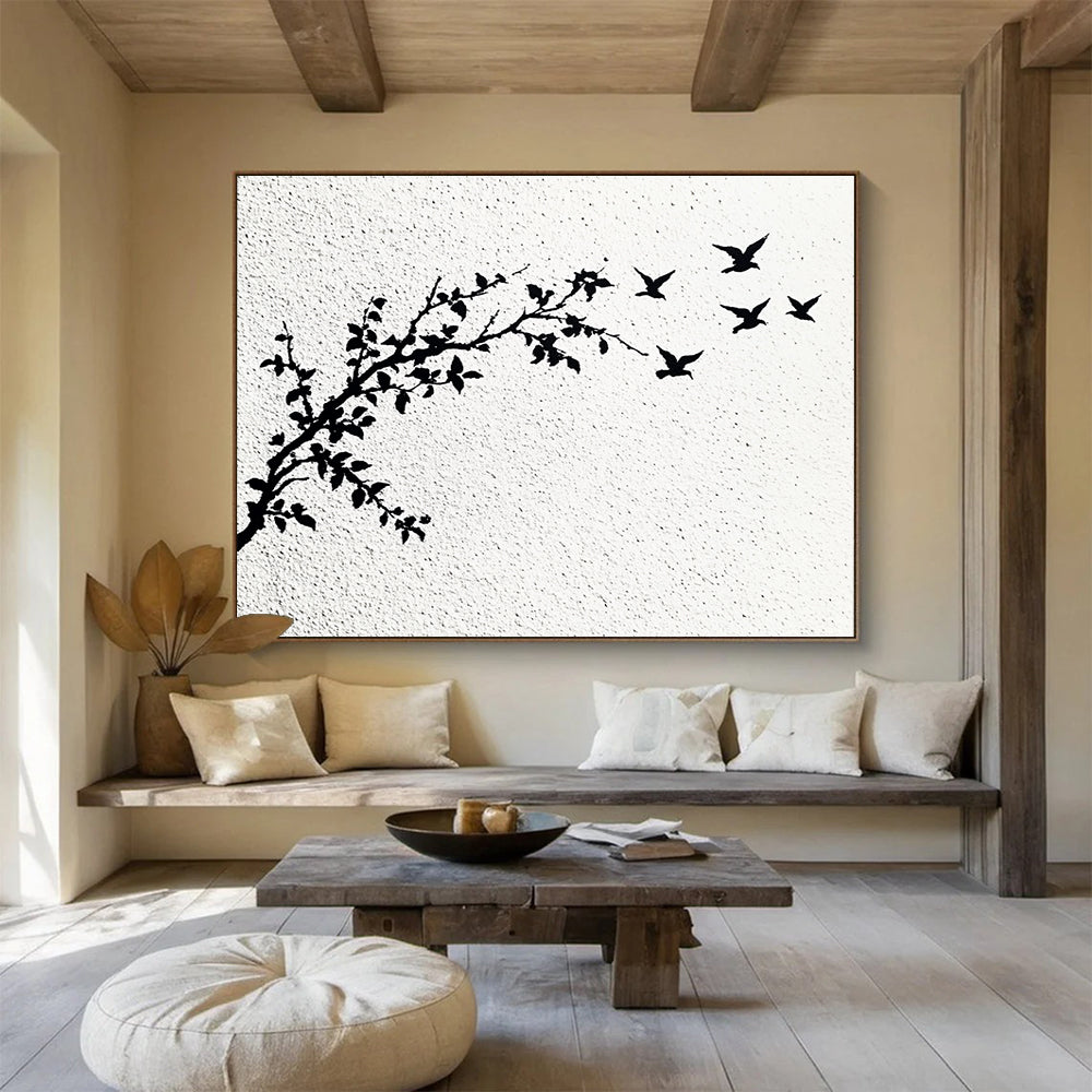 A large abstract painting featuring delicate branches with leaves and black and white flying birds against an off-white wall.SC434