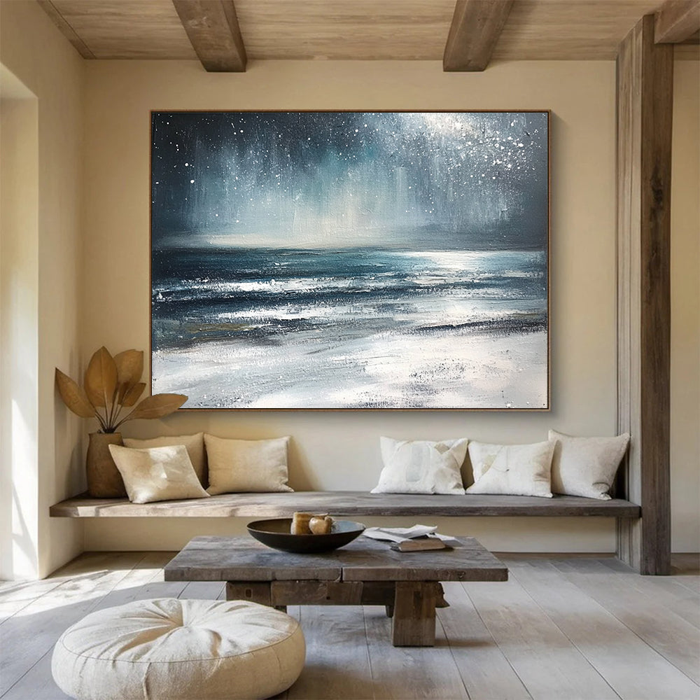 Large abstract painting depicting a winter ocean scene with dark blue and gray tones a starry white sky and sandy beach resembling snow.SC412