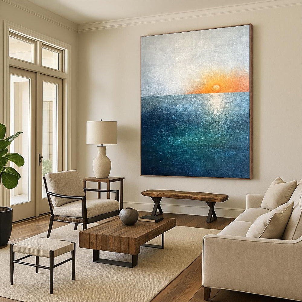 Large abstract painting featuring a soft sky blue and teal gradient with a grey expanse and a small orange sun setting on the horizon.STSC094