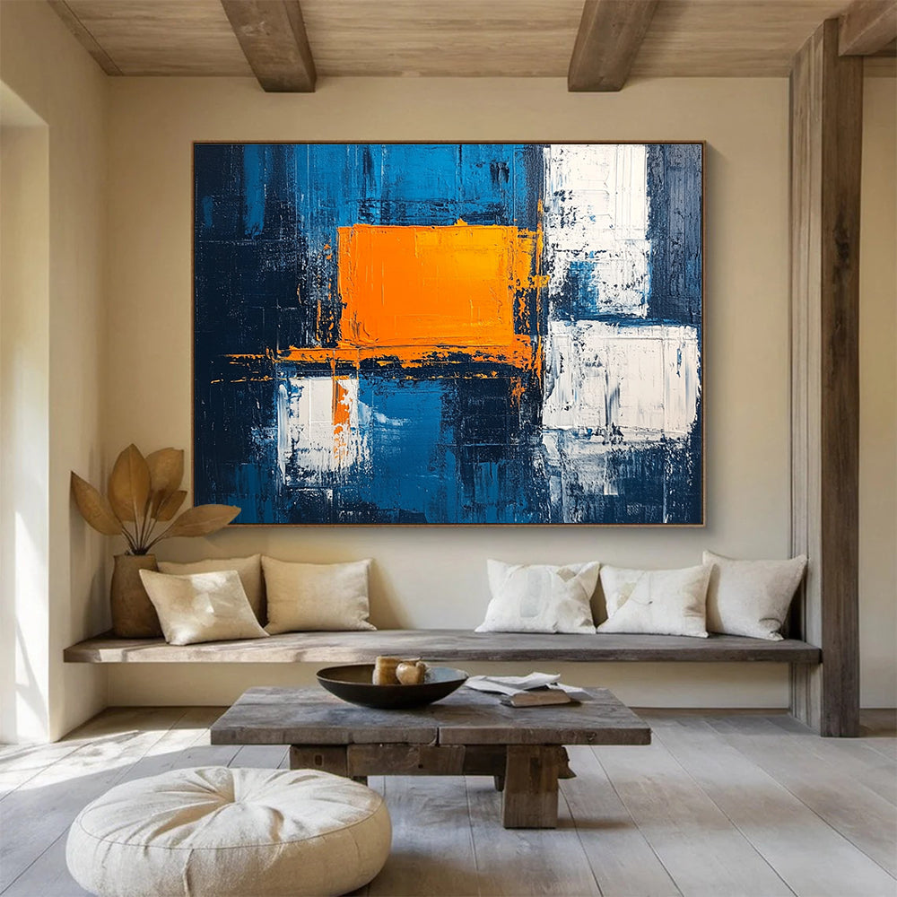 Large abstract painting featuring a textured pale blue background bold orange square white blocks and dark gray light indigo accents in acrylic.SC225