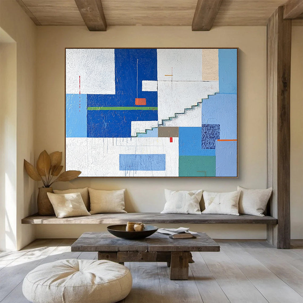 A large abstract painting of an urban landscape in blue and white tones, featuring geometric buildings with green accents, stairs, windows, and doors.SC488