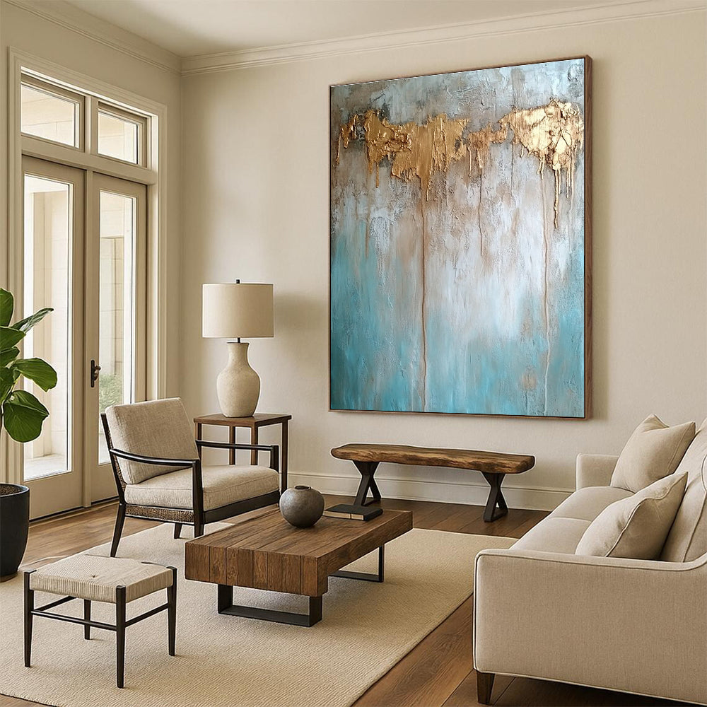 Large abstract painting with texture in neutral tones featuring light blue brown and gold hues highlighting water damage elements against a concrete wood background.STSC136