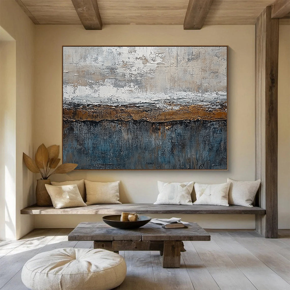 Large abstract painting features textured layers of grey, brown, blue, and bronze with painterly strokes and metal accents creating an artistic landscape.SC174