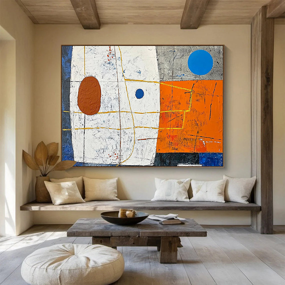 A large abstract painting featuring white squares orange and blue shapes yellow lines a small brown oval and a blue dot on a vibrant orange and dark grey background.SC376