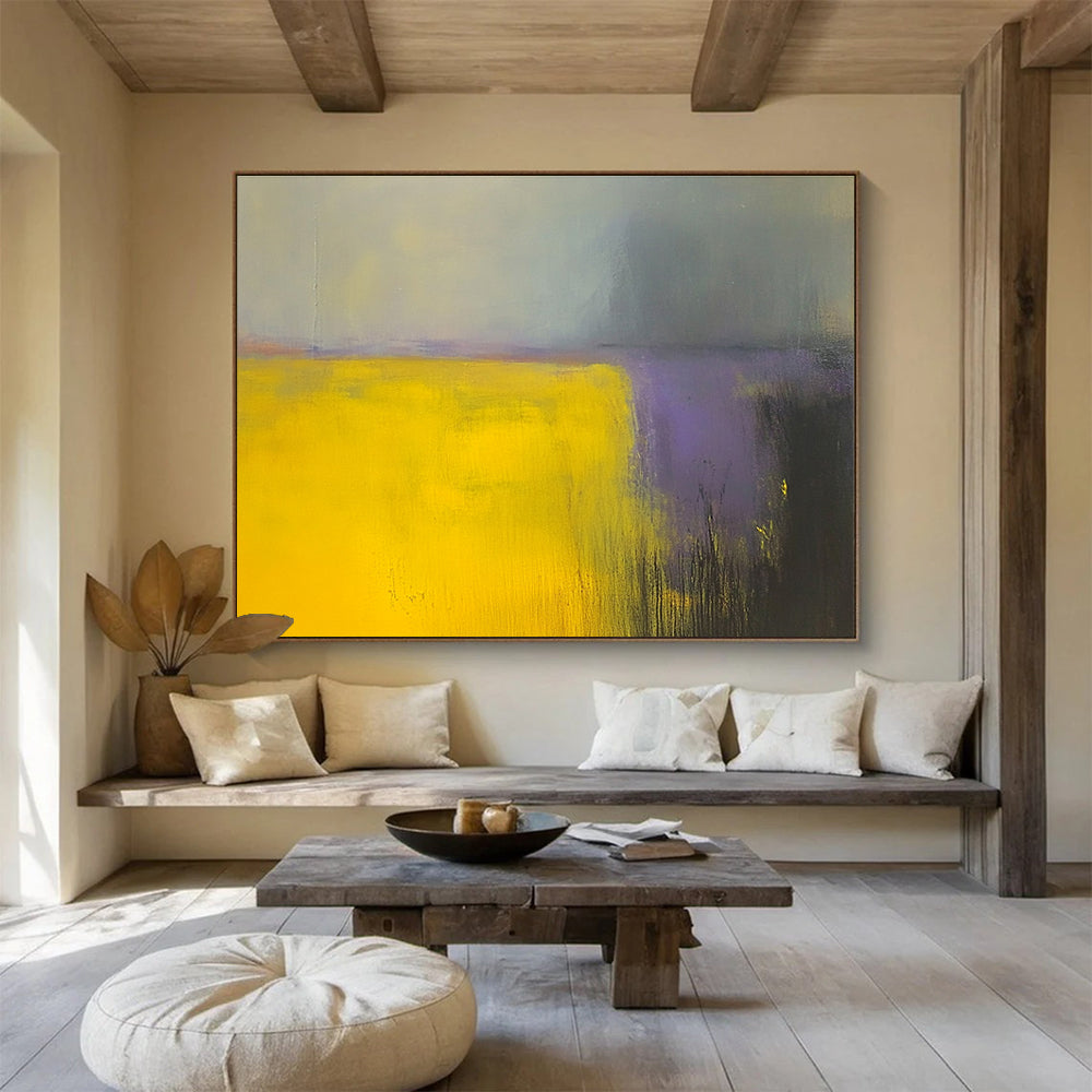 A large abstract painting featuring vibrant yellow and gray fields with subtle purple hues, enhanced by dynamic brushstrokes and a blurred background.SC475