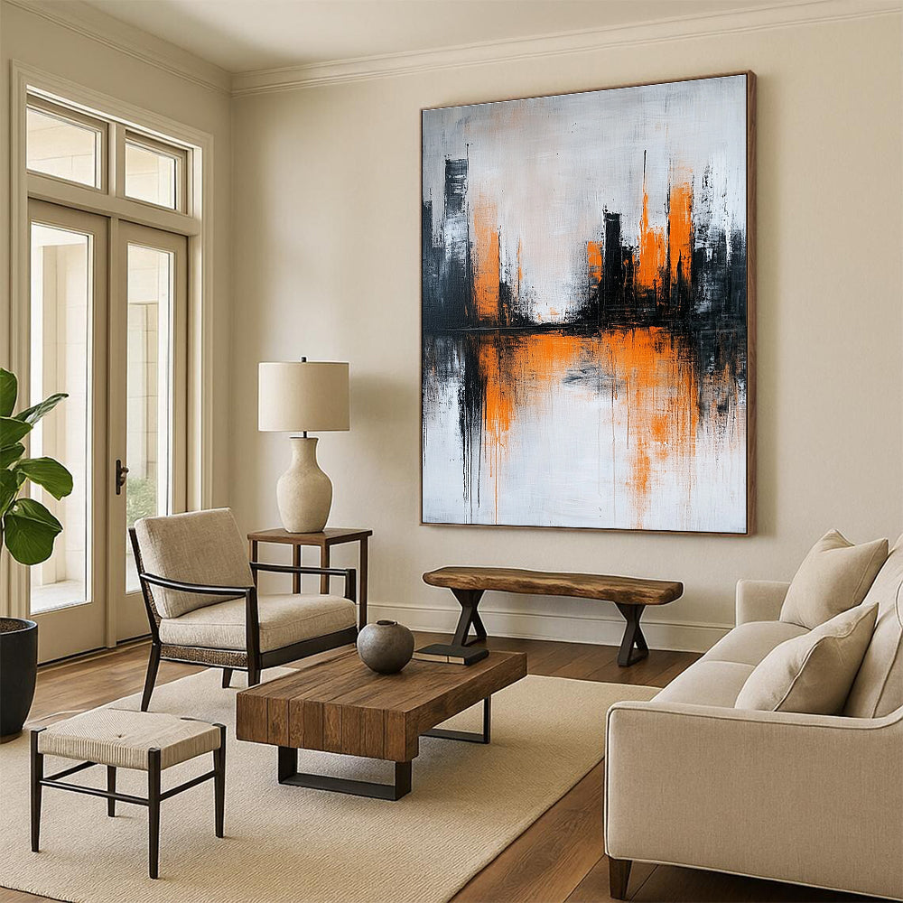 Large abstract painting featuring gray and white background with orange brushstrokes and urban landscape silhouette reflecting on water surface.STSC225
