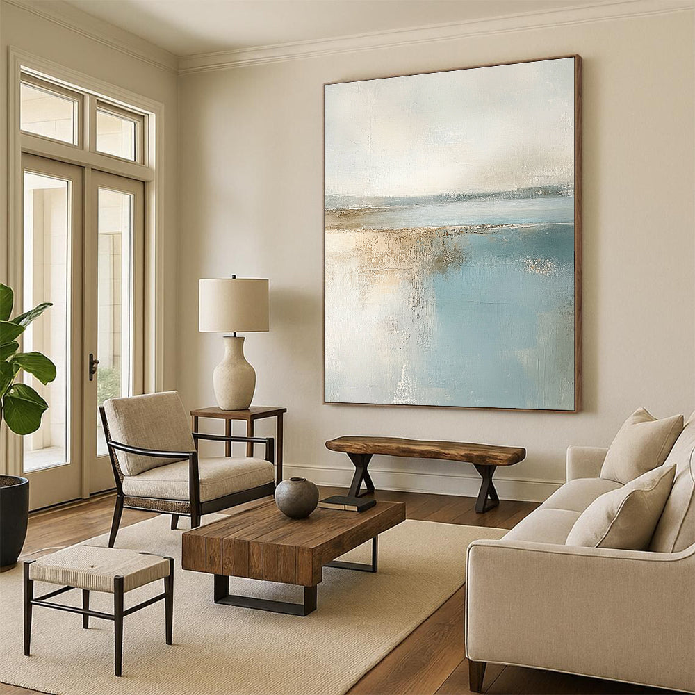 Large abstract painting featuring muted pastel colors of beige and light blue creating a calming beach landscape in neutral tones.STSC017