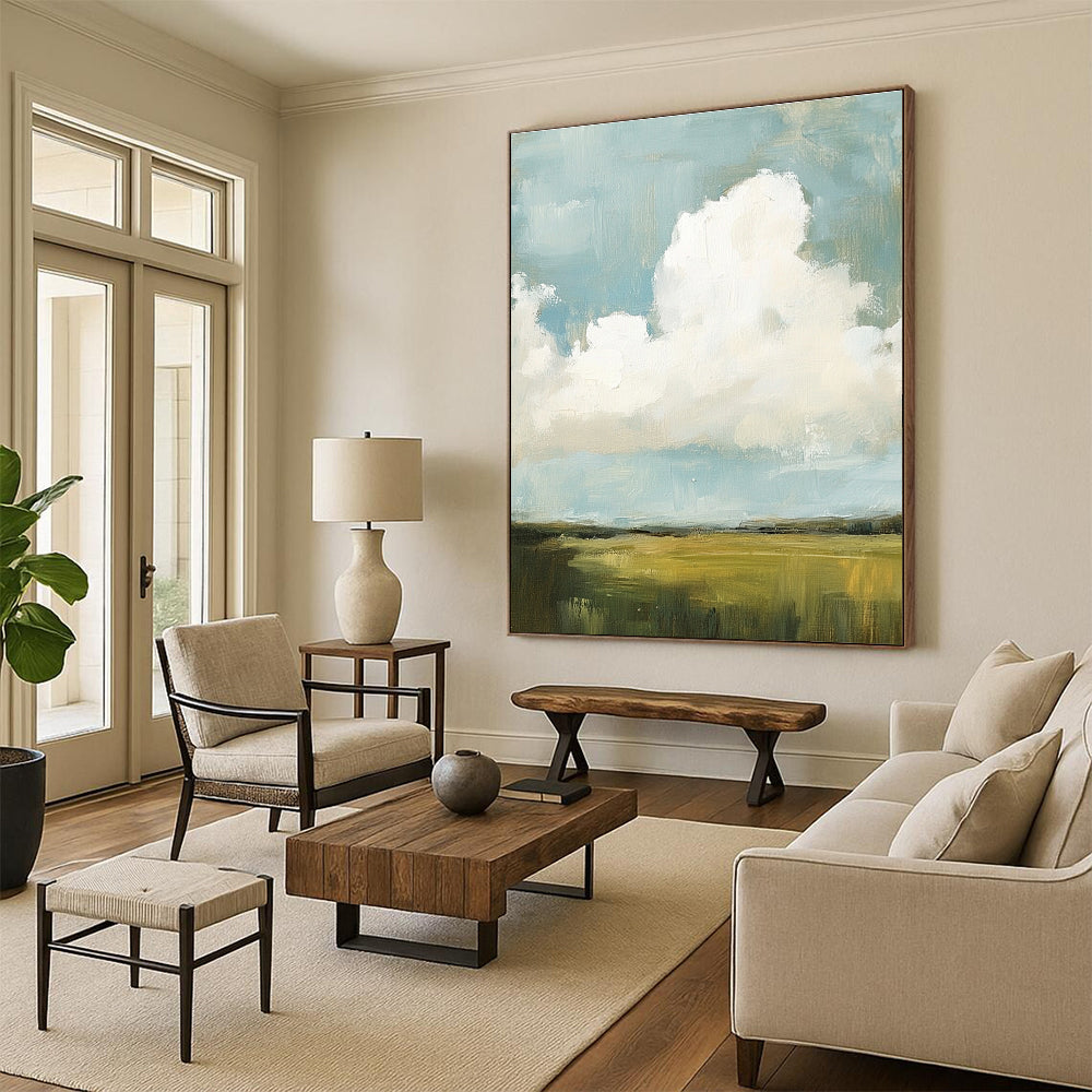 Large abstract painting featuring fluffy white and gray clouds over green grass fields with visible brush strokes and muted colors, creating a detailed scene.STSC873