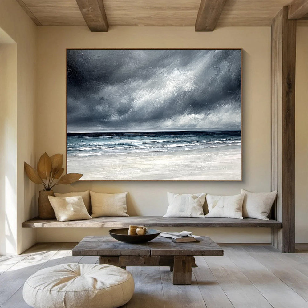 Large abstract painting featuring an ocean with stormy gray clouds and a white sand beach in soft gray and blue tones.SC163