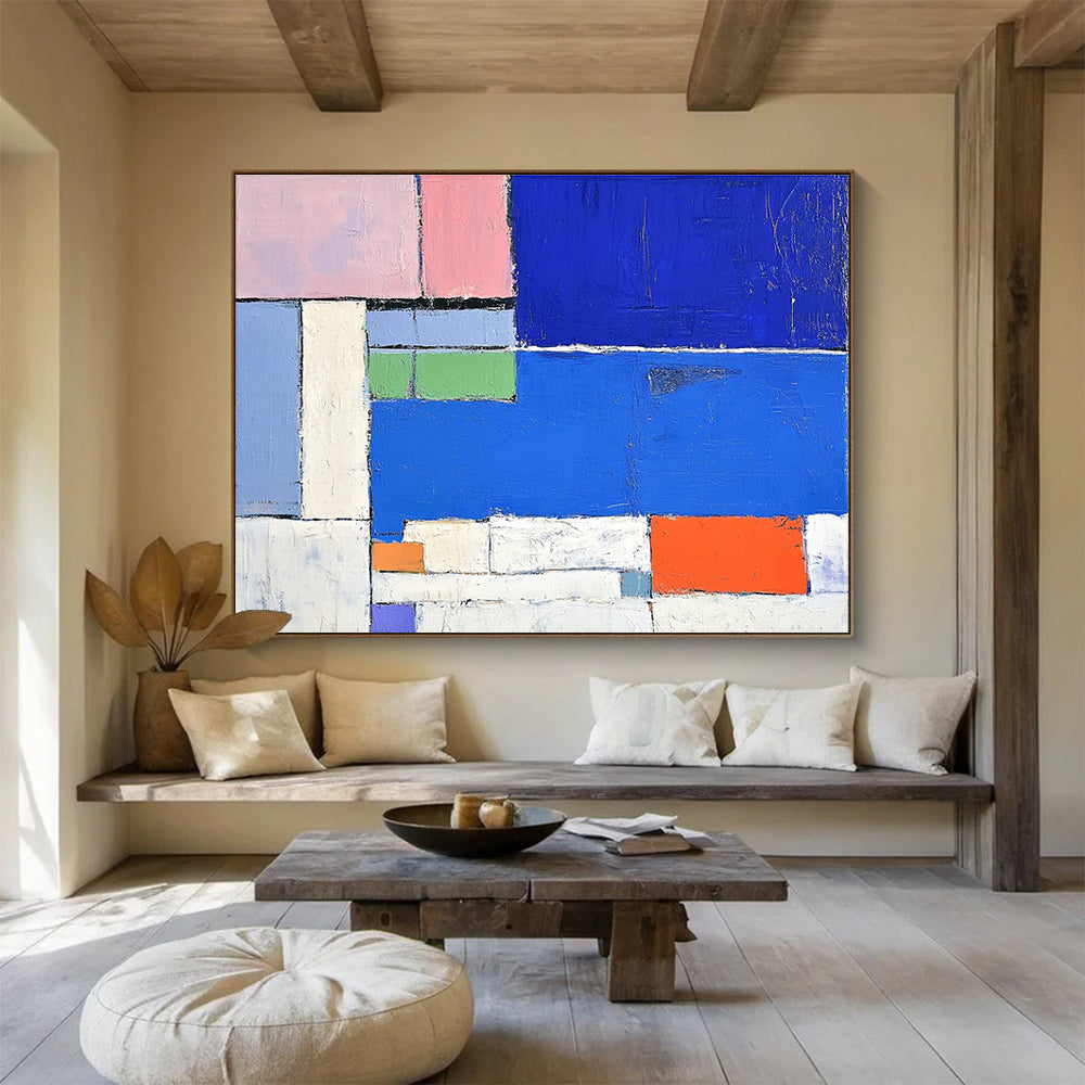 Large abstract painting featuring a vibrant blue sea white beach and colorful hotel with thick brush strokes and geometric shapes.SC169