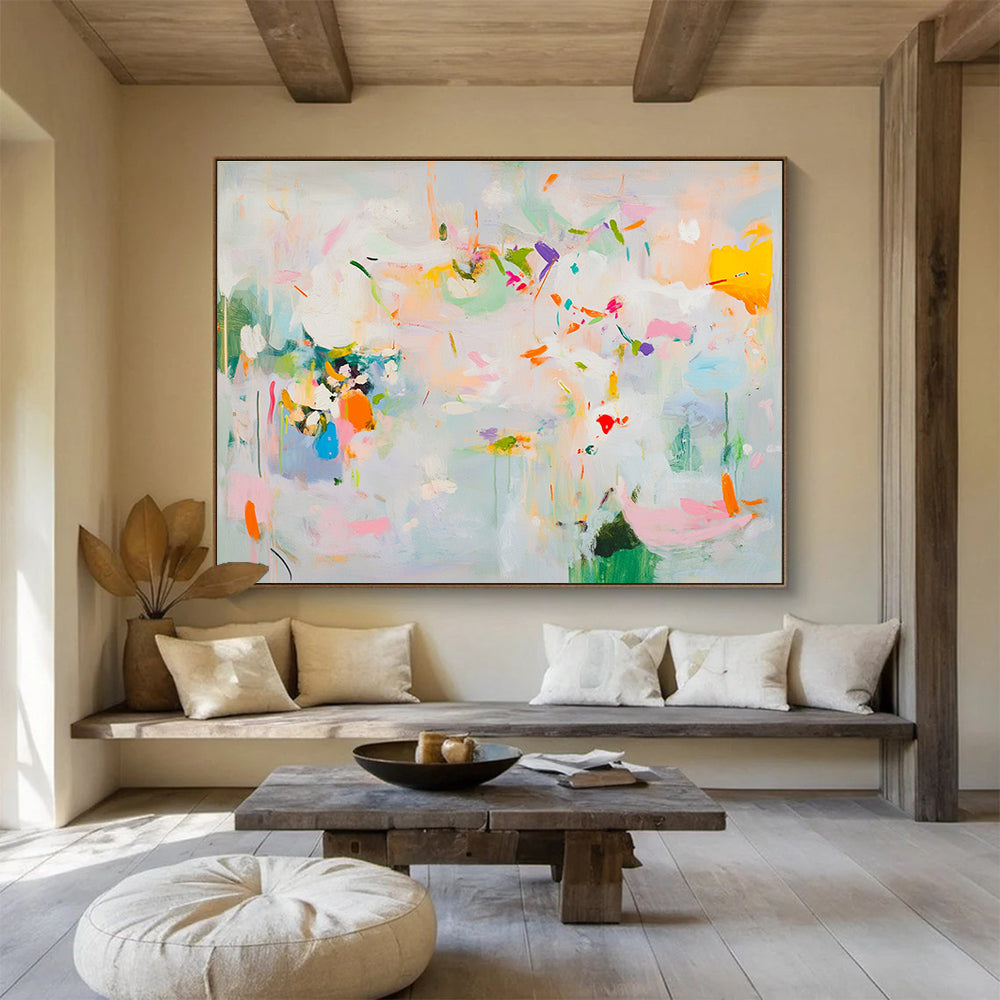 Large abstract painting in soft pastels featuring spring themes with flowers leaves trees and vibrant splashes of color creating a lively atmosphere.SC384