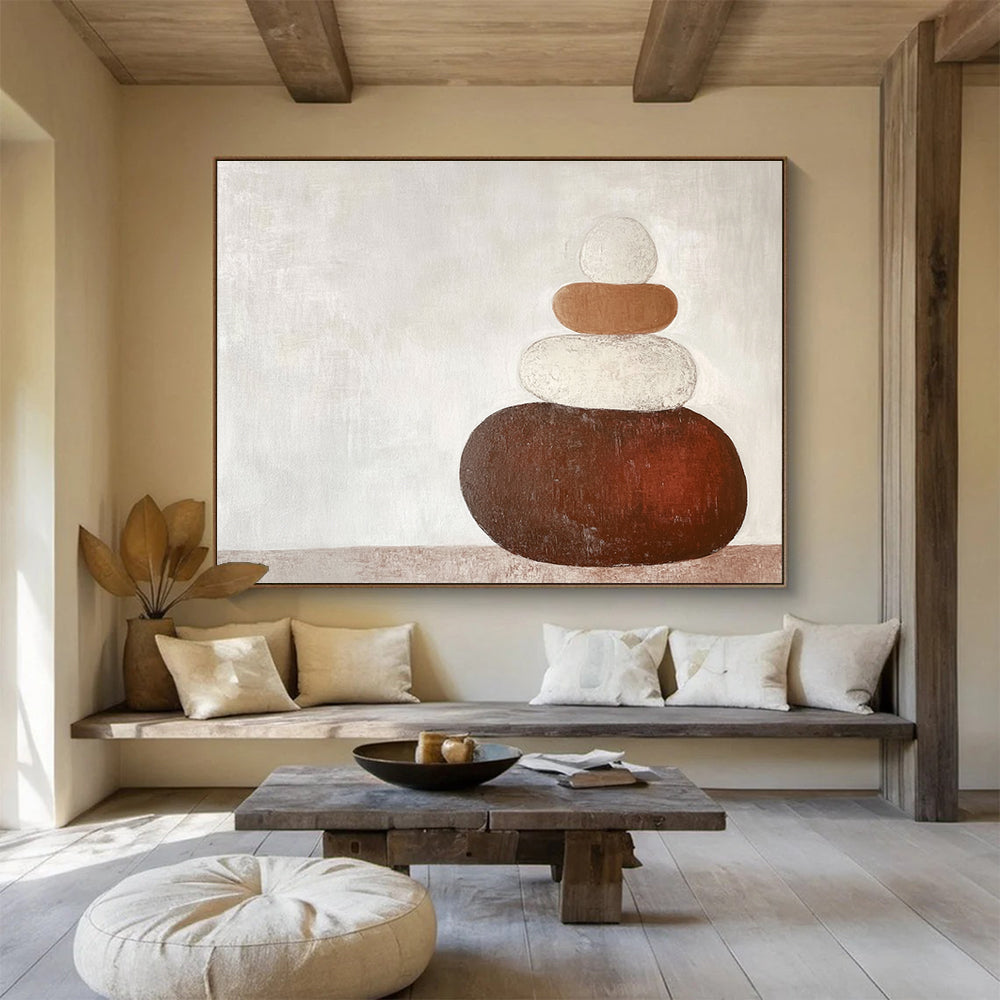 Large abstract painting in earth tones featuring three stacked rocks against a white background creating an elegant contrast.SC495
