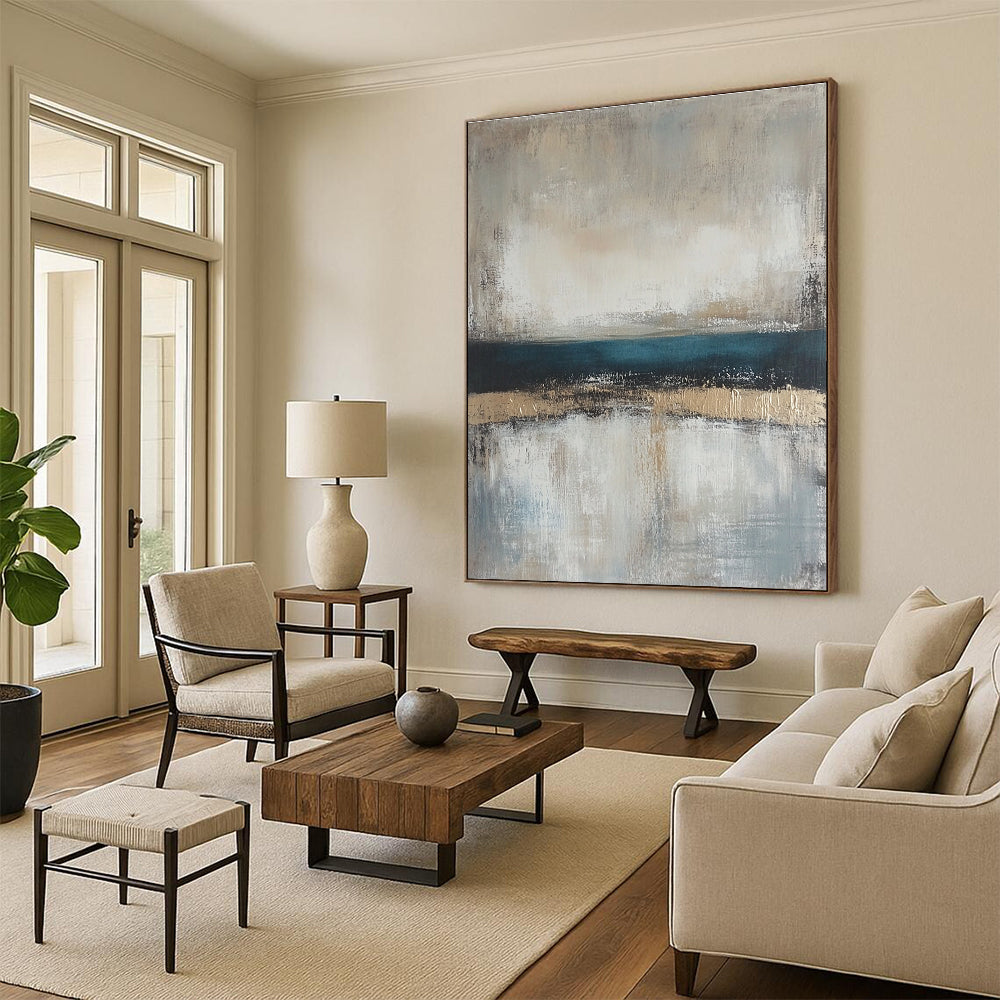 Large abstract painting featuring neutral colors and soft tones of beige gray and blue with a serene horizon line.STSC462
