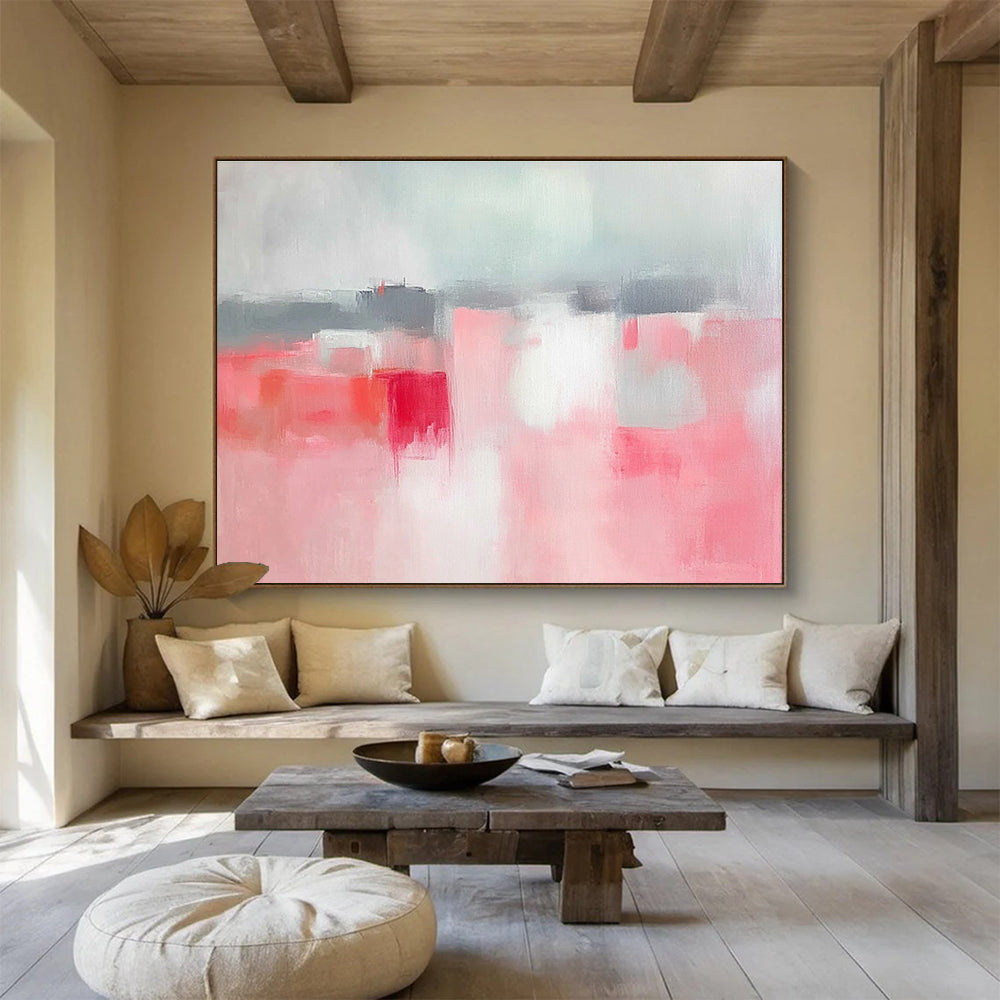 Large abstract painting featuring soft pink and grey tones, white space, sky blue, red accents, and a blurred town background.SC257
