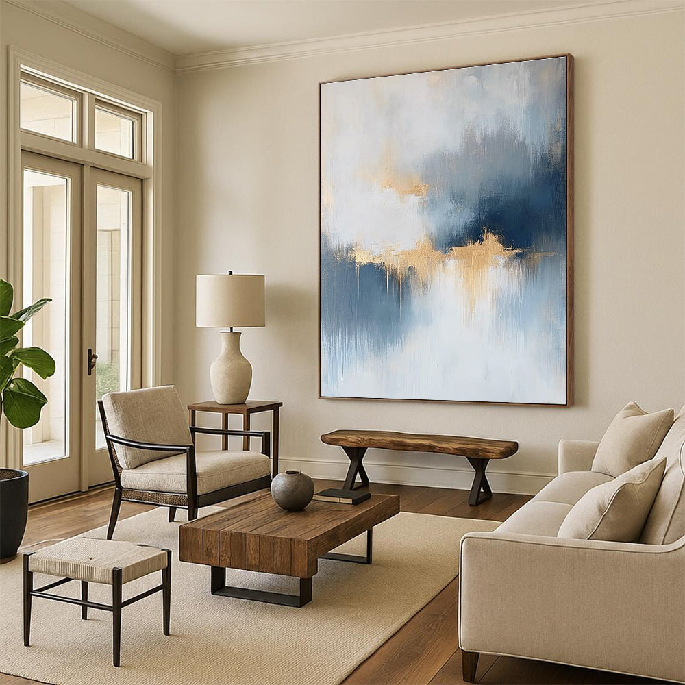 Large abstract painting featuring atmospheric clouds in soft blue gray and white tones with gold and silver accents and delicate textures.STSC386