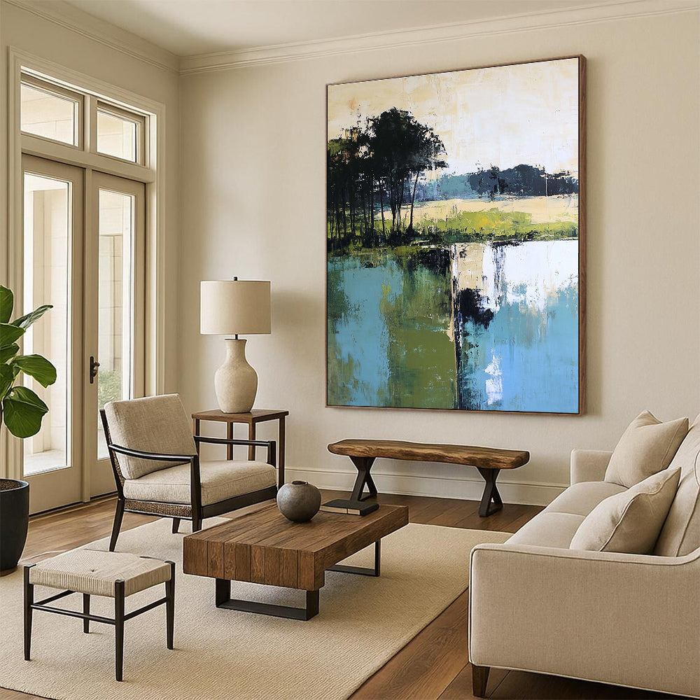 Large abstract painting featuring green blue and beige hues with distant trees foreground trees and green grass by the water.STSC098