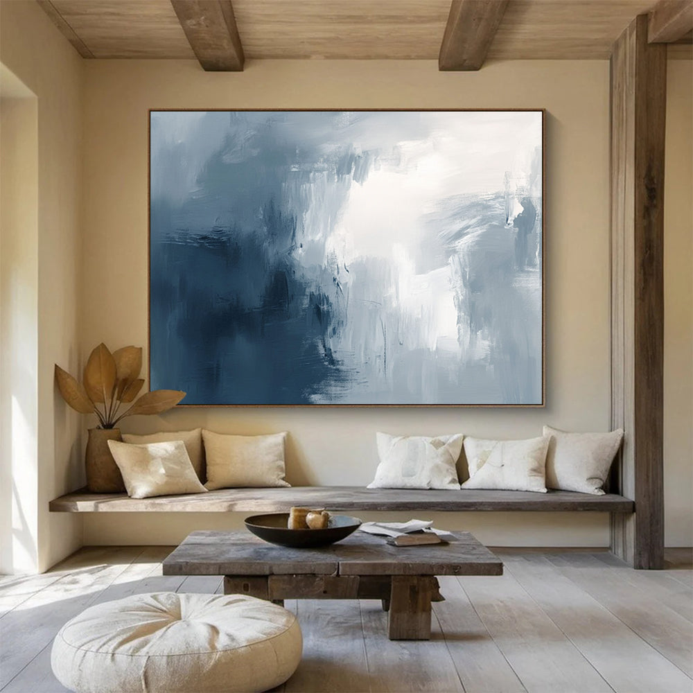 Large abstract painting with broad brush strokes in gray white and navy blue evoking calmness and introspection through soft gradients.SC048