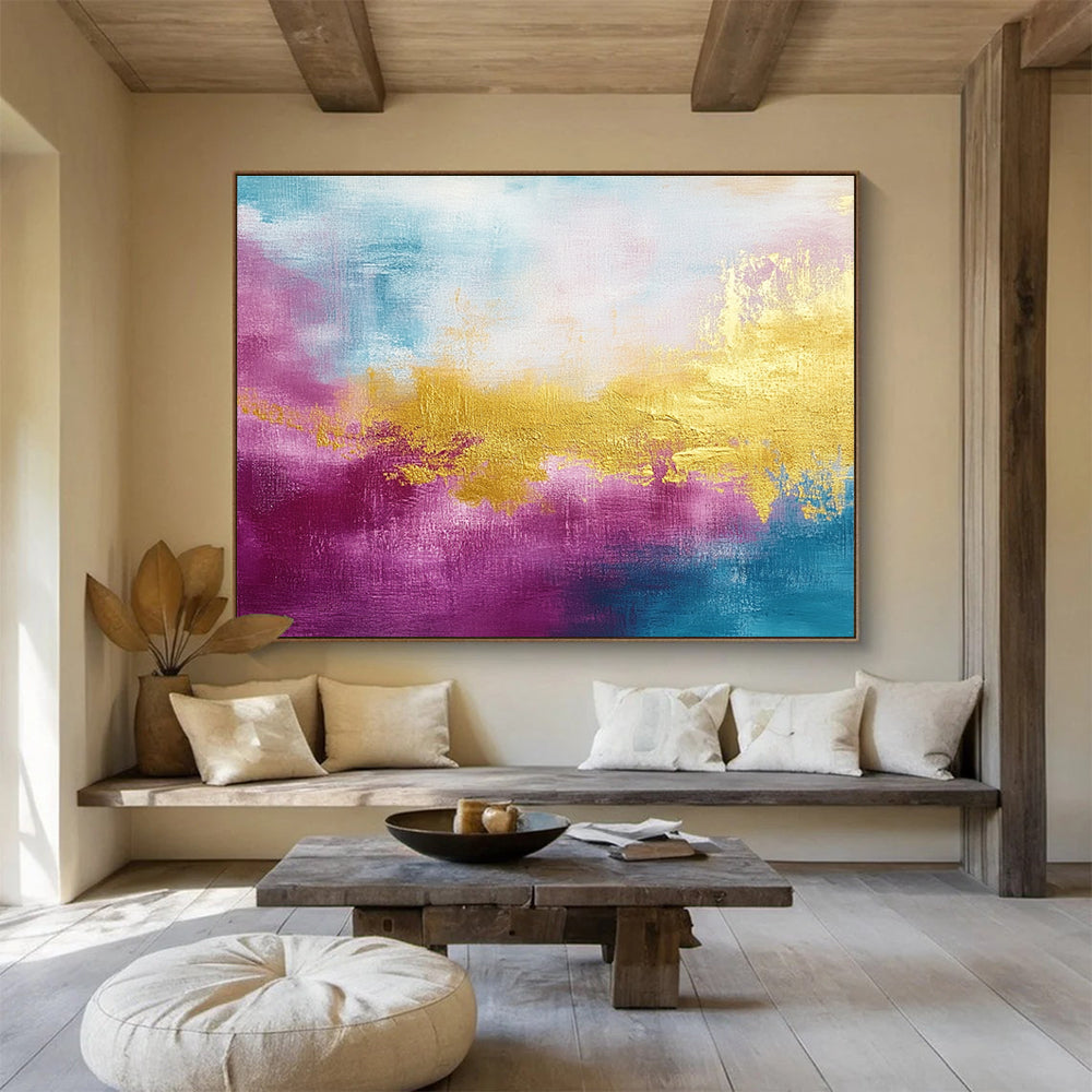 A large abstract painting features gold, magenta, and cyan hues with soft brush strokes and a tranquil water-inspired backdrop.SC322