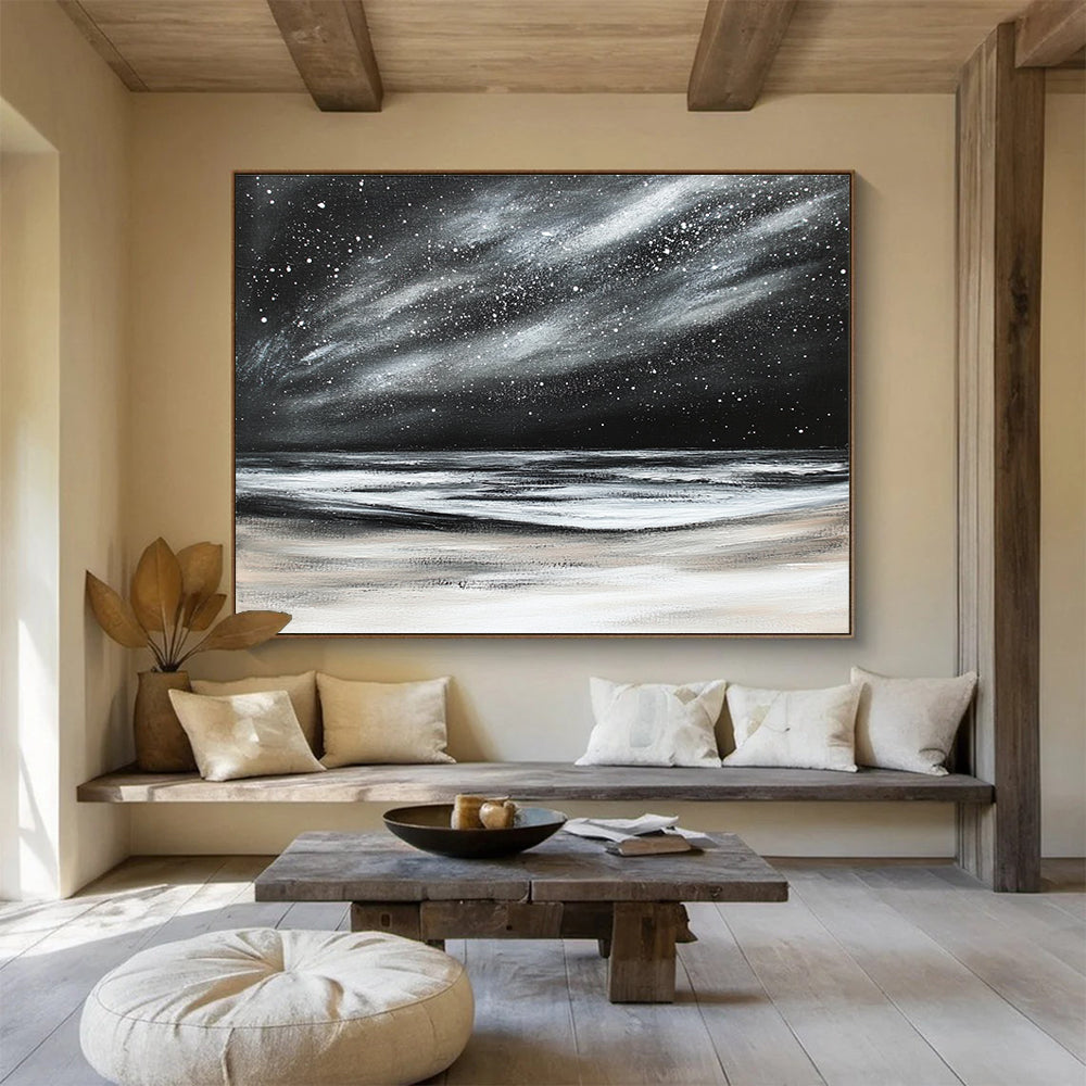 Large abstract painting depicting a dark stormy sky with stars and snow on the beach in black and white colors.SC295