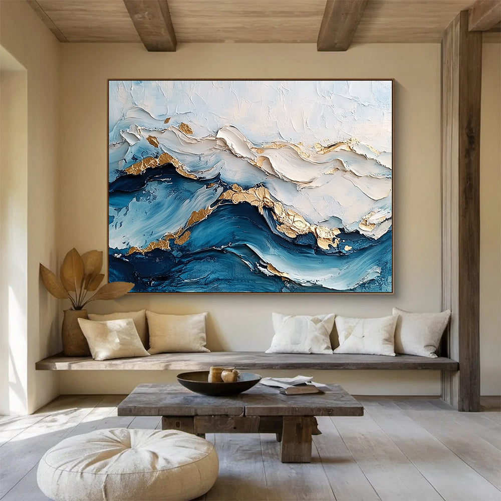 Large abstract painting featuring ocean waves in textured white and blue hues with gold accents for depth and elegance.SC102