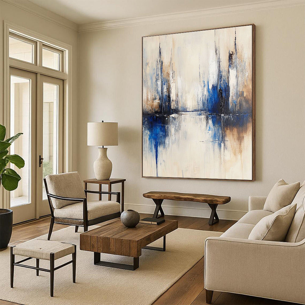 Large abstract painting of a city with muted white and blue tones on a beige background featuring blurred brush strokes reflecting in water.STSC134