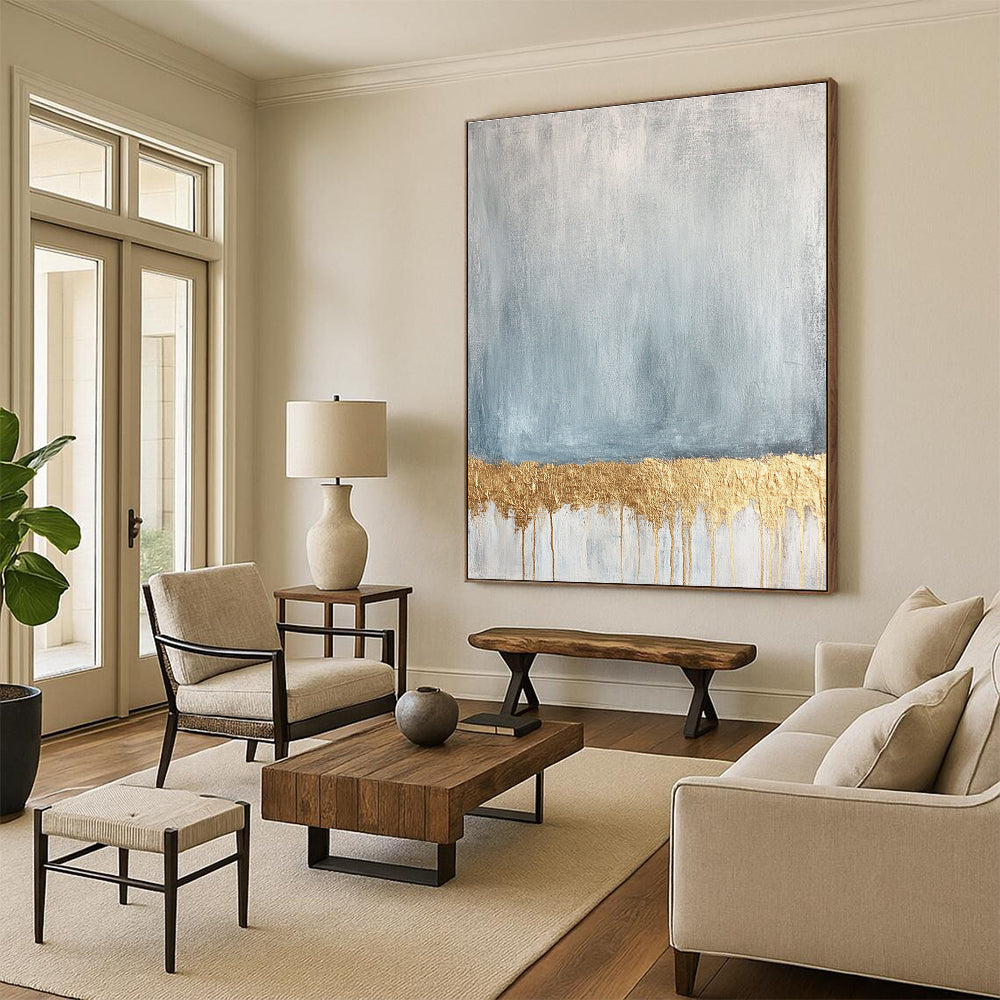 Large abstract painting featuring a textured pale blue and gold palette with a gold metallic foil line across a soft grey and white background.STSC571