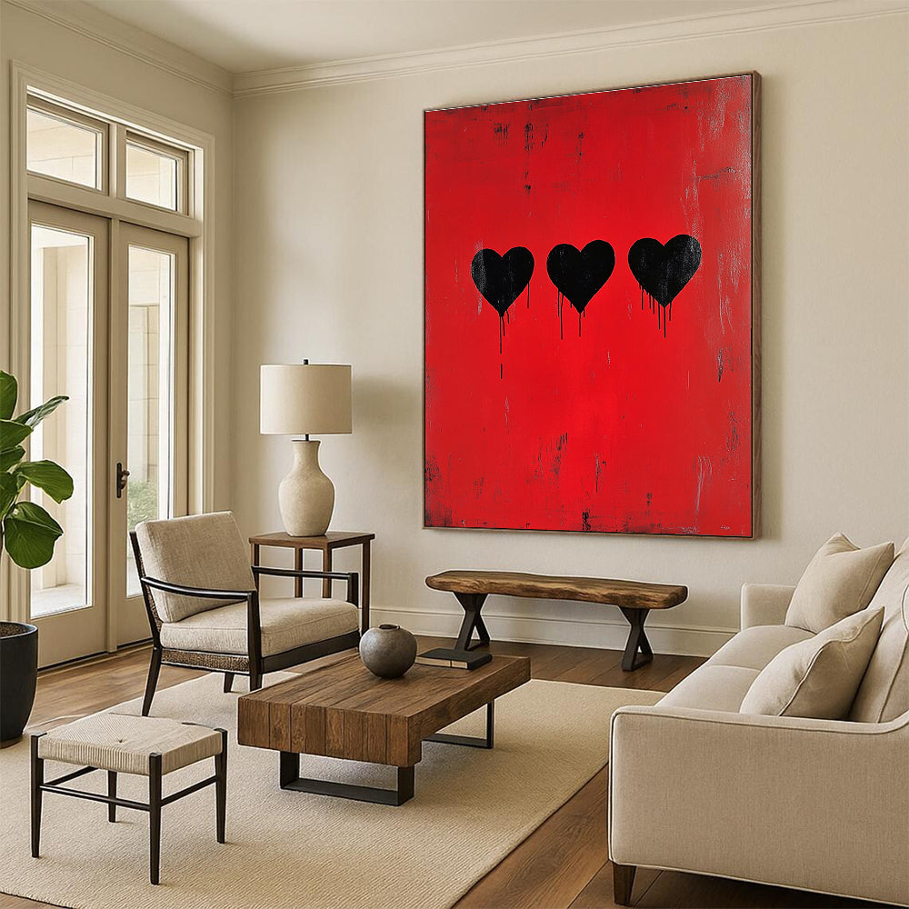 A large abstract painting featuring three black hearts on a red background inspired by Banksy’s minimalistic style.STSC1442