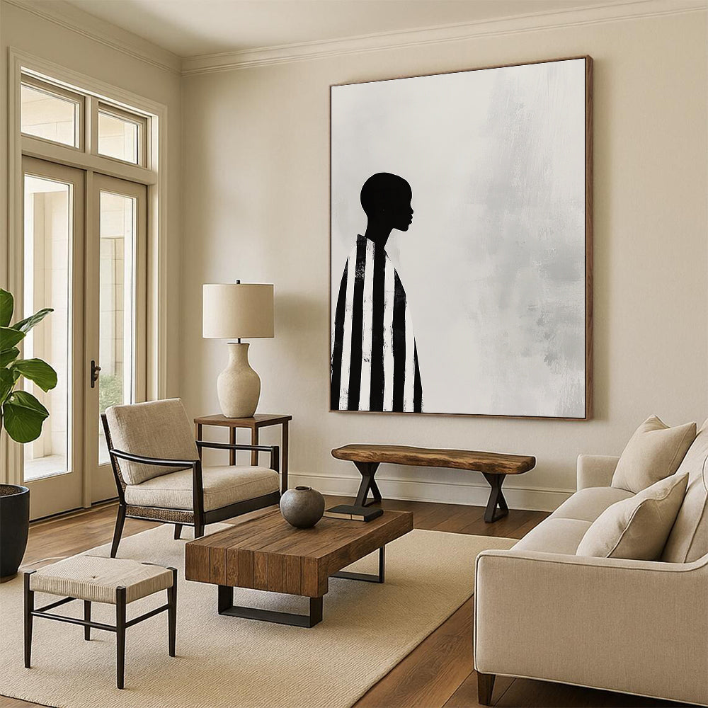 A large abstract painting featuring a striking black and white profile of an African woman in striped robes against a soft gray background.STSC1079