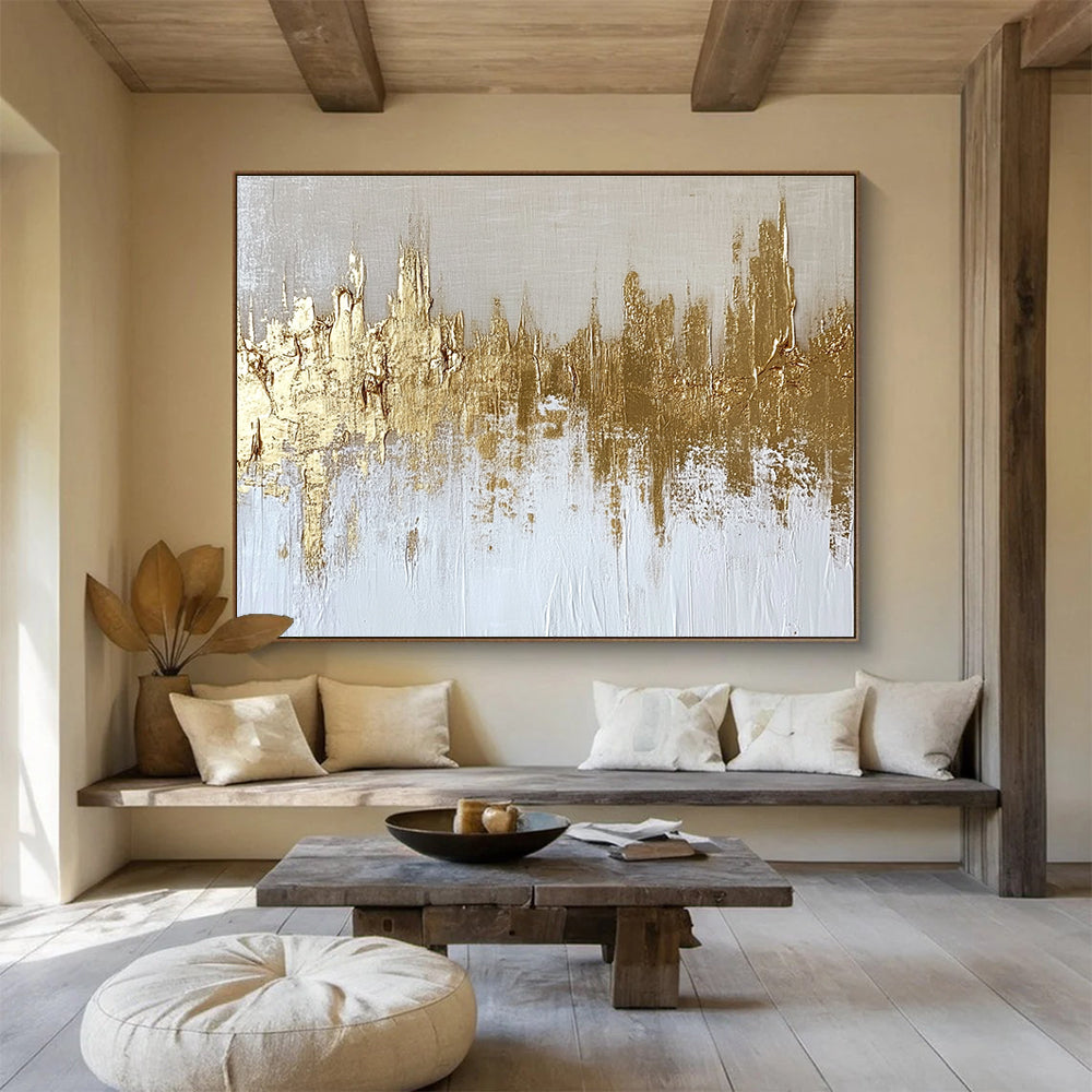 Large abstract painting of a gold and white cityscape with textured canvas and gold foil accents on a neutral background.SC173