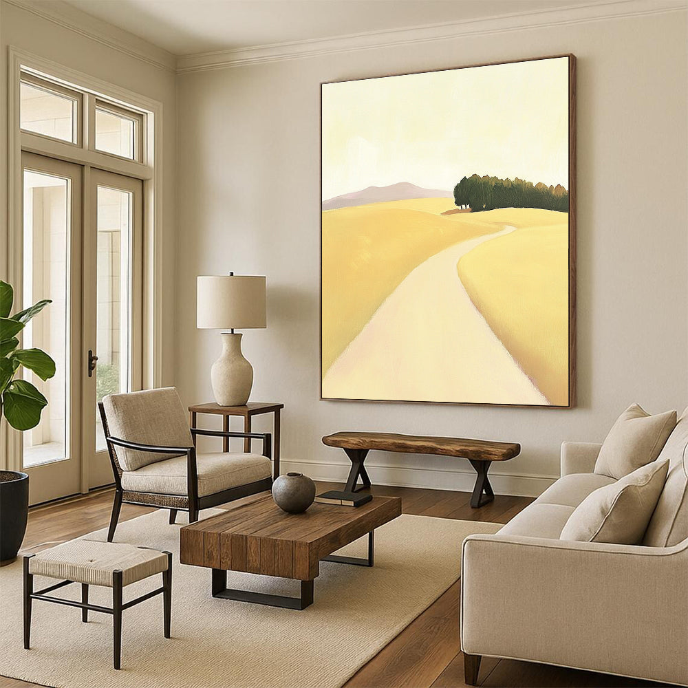 A large abstract painting depicting a minimalist road in an open field with hills and trees in soft yellow beige and green tones.STSC1167