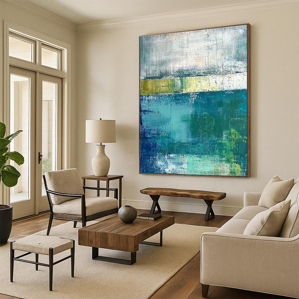 Large abstract painting with green and blue tones on a gray background evokes a serene water's edge mood with textured surfaces.STSC420