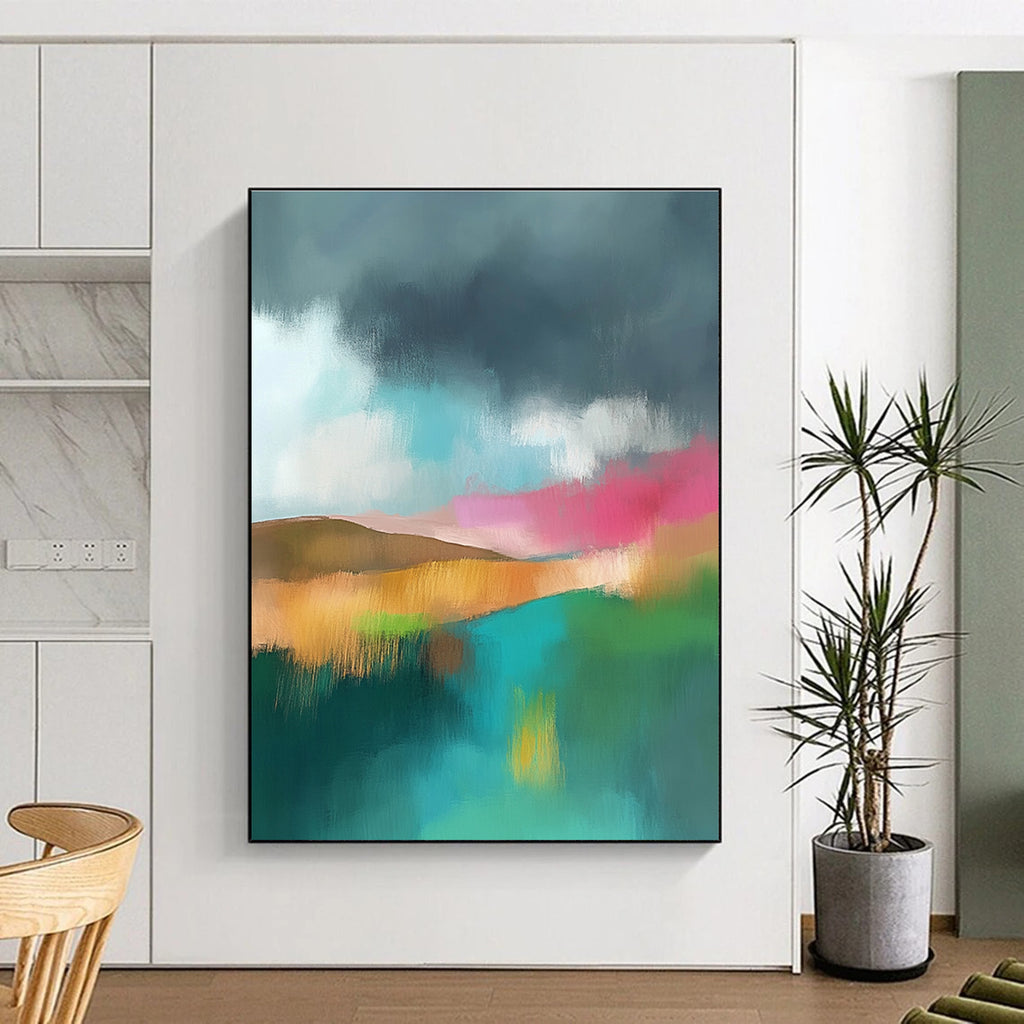 Large abstract painting featuring light teal and pink hues with a green field brown hills and a dark grey sky adorned with white clouds.STSC087
