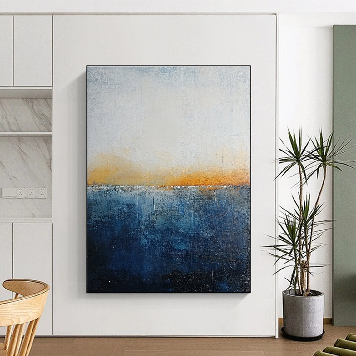 Large abstract painting with layered blue and yellow textures evokes oceanic depths at dusk with soft lighting enhancing movement and depth.STSC109