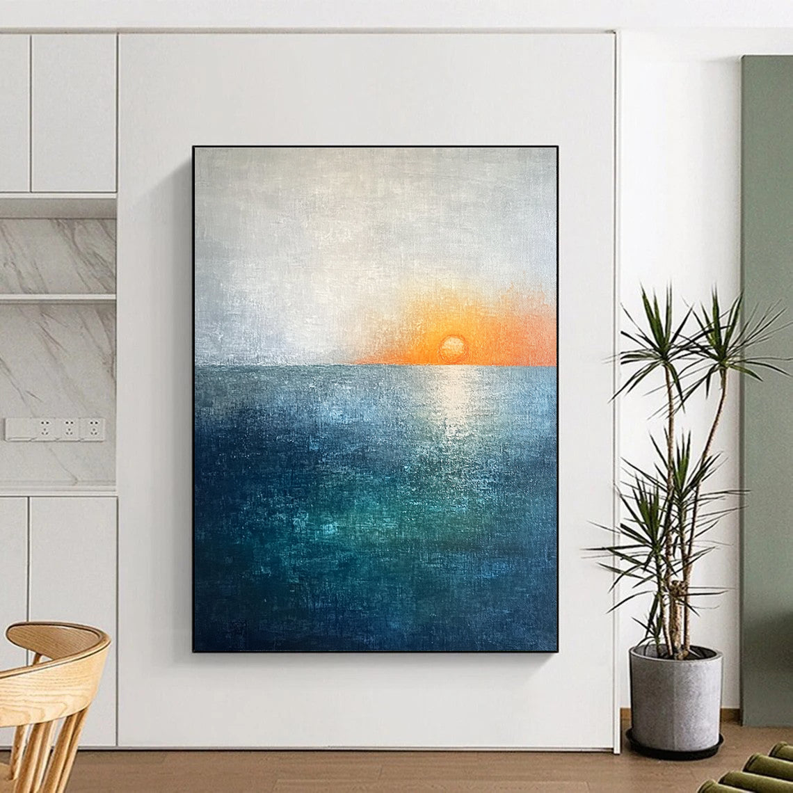 Large abstract painting featuring a soft sky blue and teal gradient with a grey expanse and a small orange sun setting on the horizon.STSC094