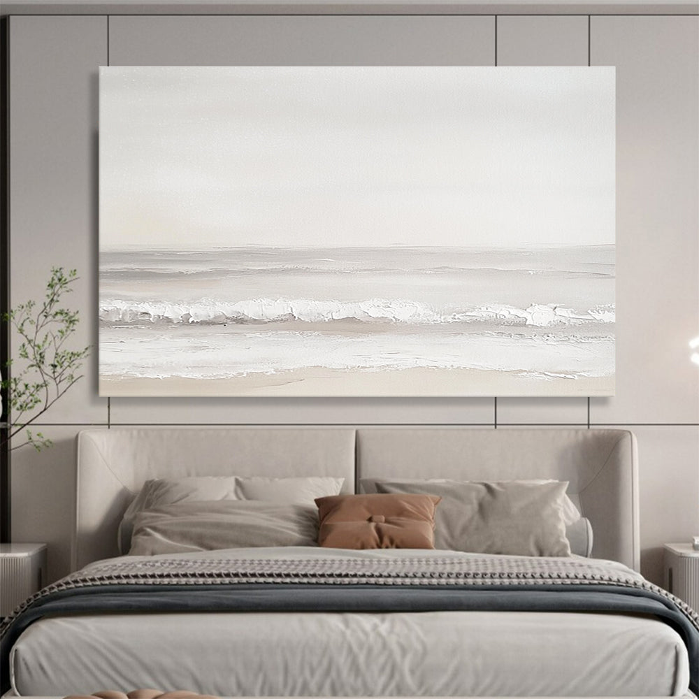 A large abstract painting of the sea featuring light gray and white tones with serene waves and a beige beach for added depth.SC502