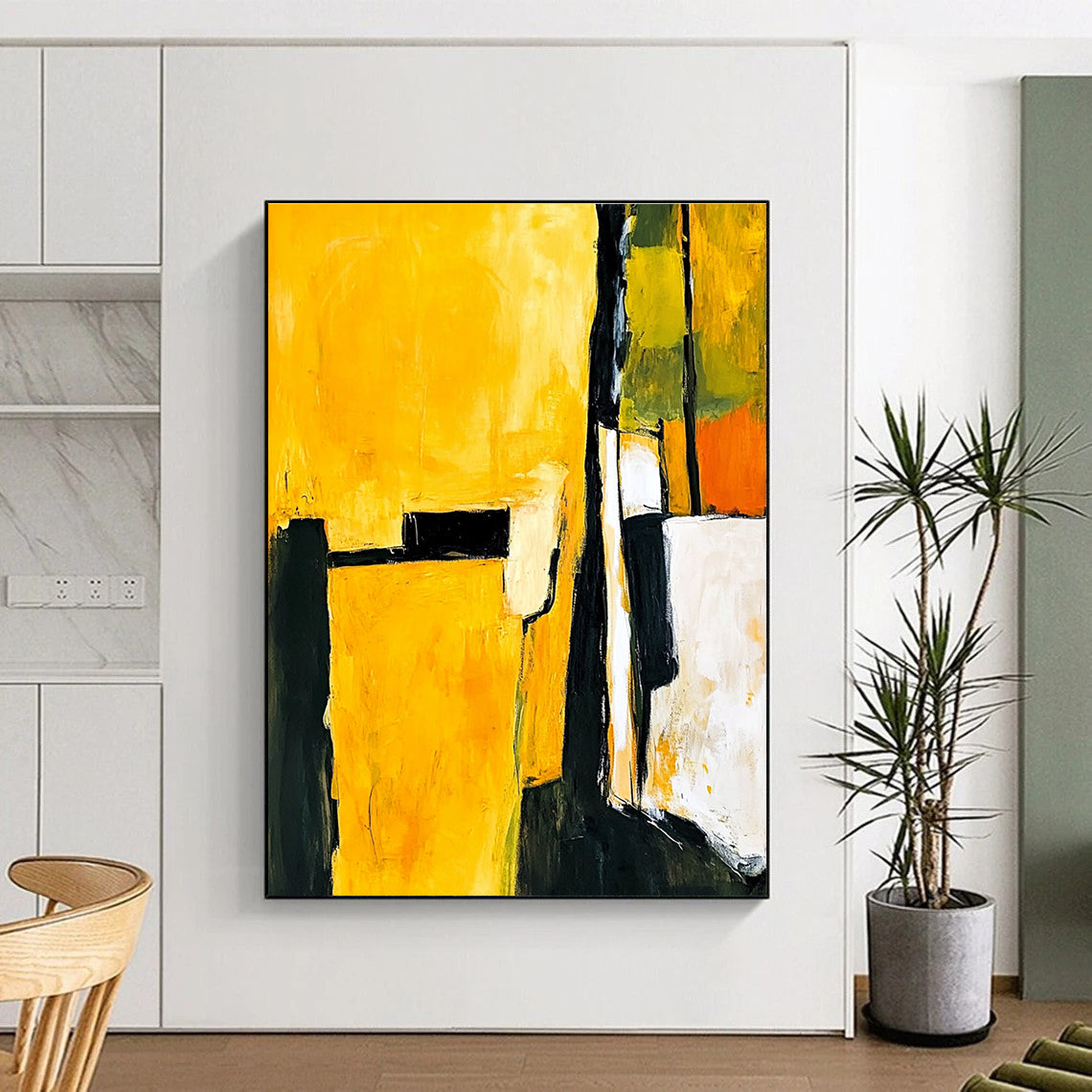 Abstract painting in yellow and black featuring white shapes with a minimalist atmosphere and an armchair in the foreground.STSC718