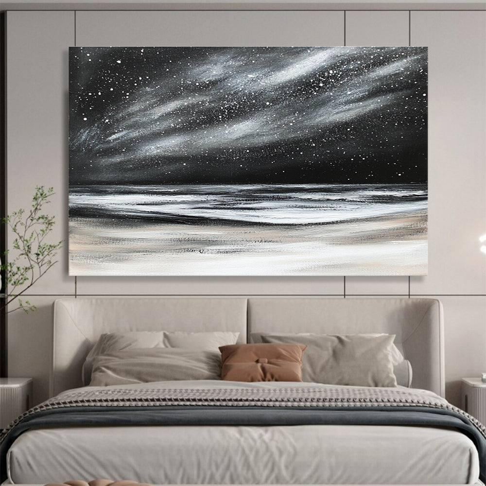 Large abstract painting depicting a dark stormy sky with stars and snow on the beach in black and white colors.SC295