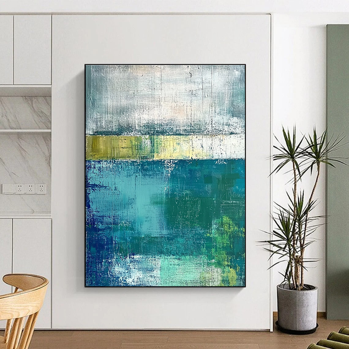 Large abstract painting with green and blue tones on a gray background evokes a serene water's edge mood with textured surfaces.STSC420