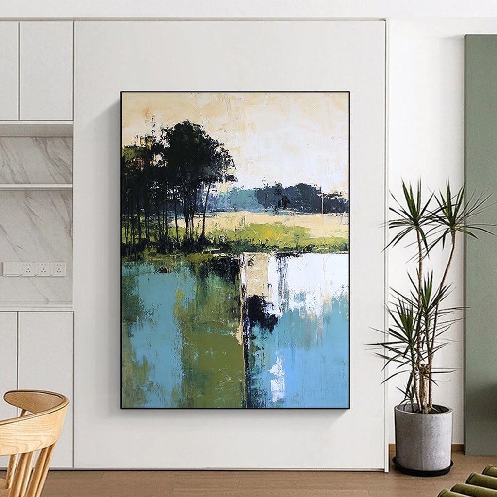 Large abstract painting featuring green blue and beige hues with distant trees foreground trees and green grass by the water.STSC098