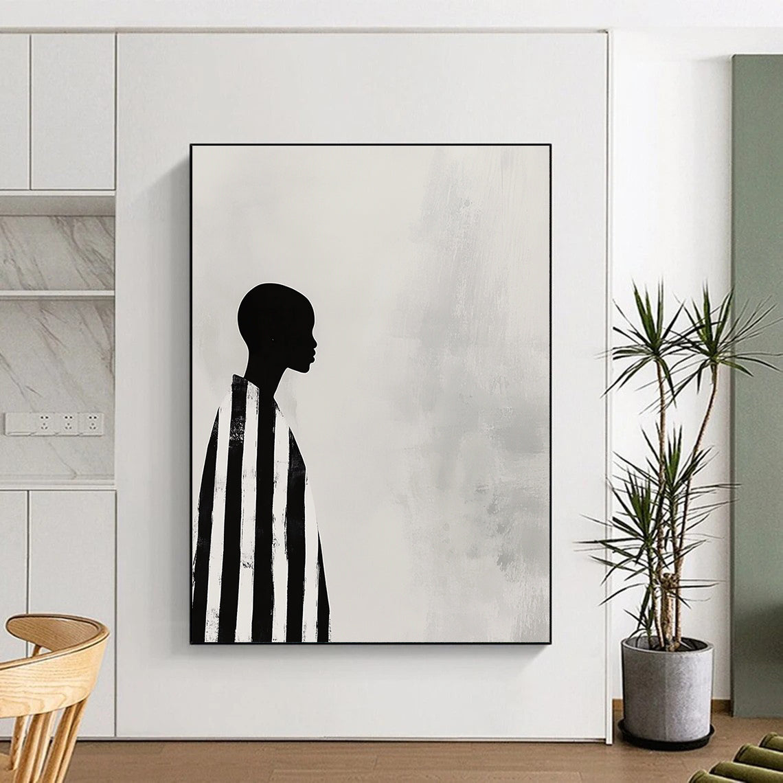 A large abstract painting featuring a striking black and white profile of an African woman in striped robes against a soft gray background.STSC1079