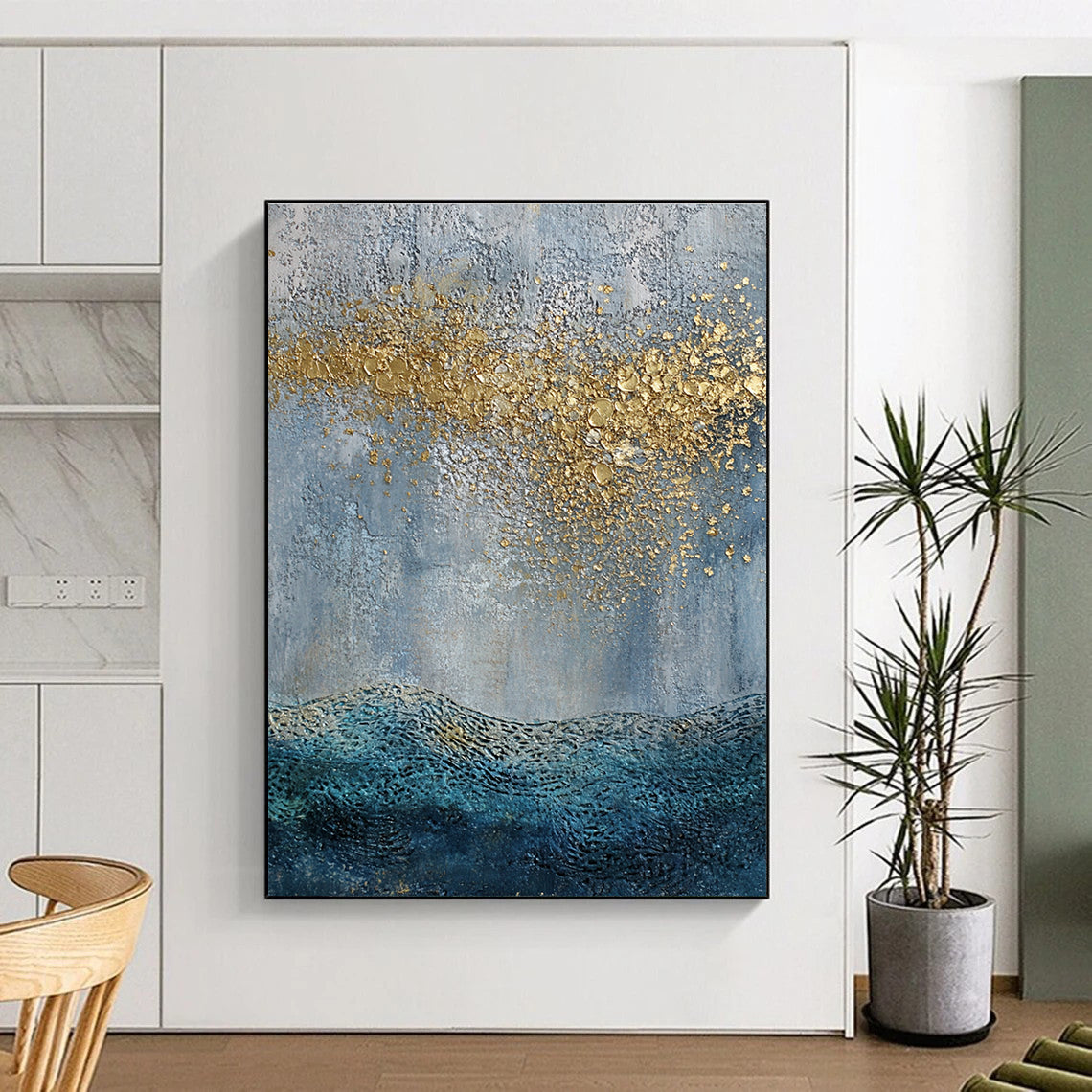 Large abstract painting with a textured sky-blue gray background and golden highlights featuring a textured sea with gentle waves in the foreground.STSC835