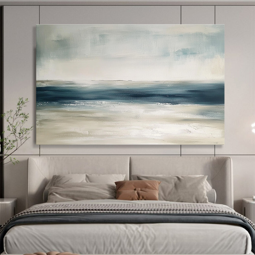 Large abstract painting featuring tranquil blue and gray tones with sandy beige hints soft brushstrokes evoke a serene ocean landscape.SC277