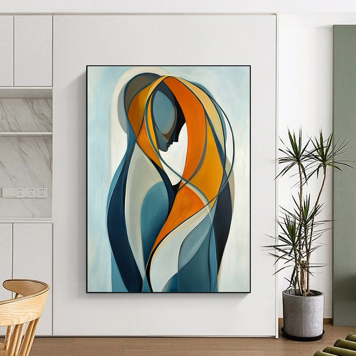 Large abstract painting of two intertwined figures in vibrant orange and yellow against a light blue background emphasizing connection and softness.STSC1143