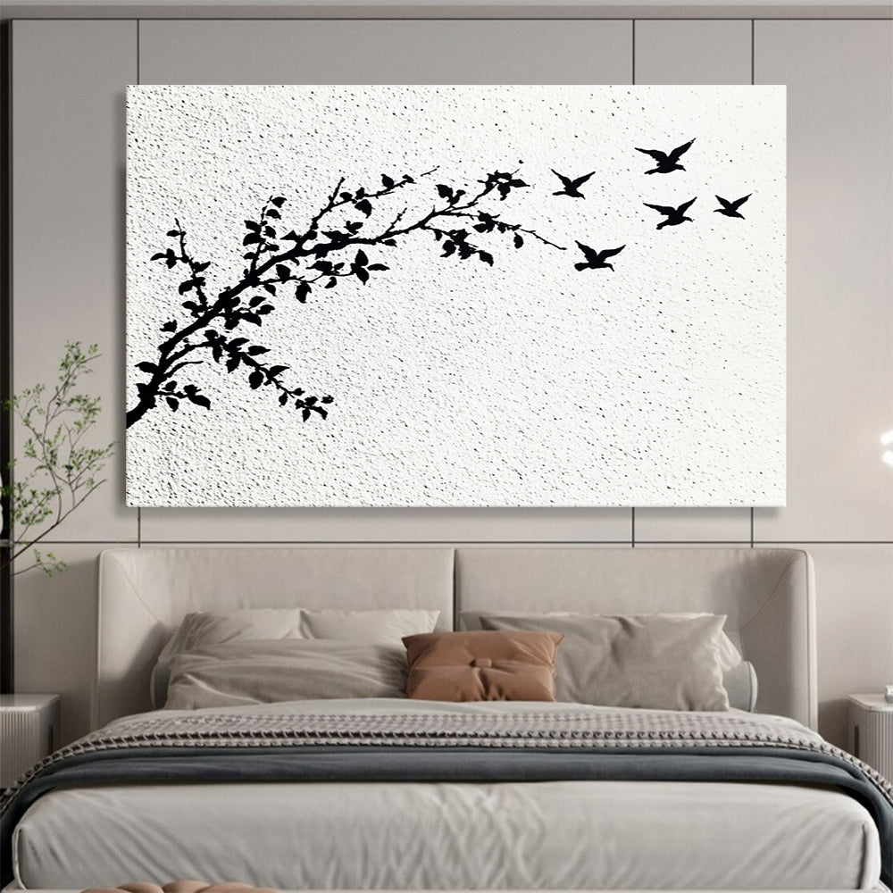 A large abstract painting featuring delicate branches with leaves and black and white flying birds against an off-white wall.SC434