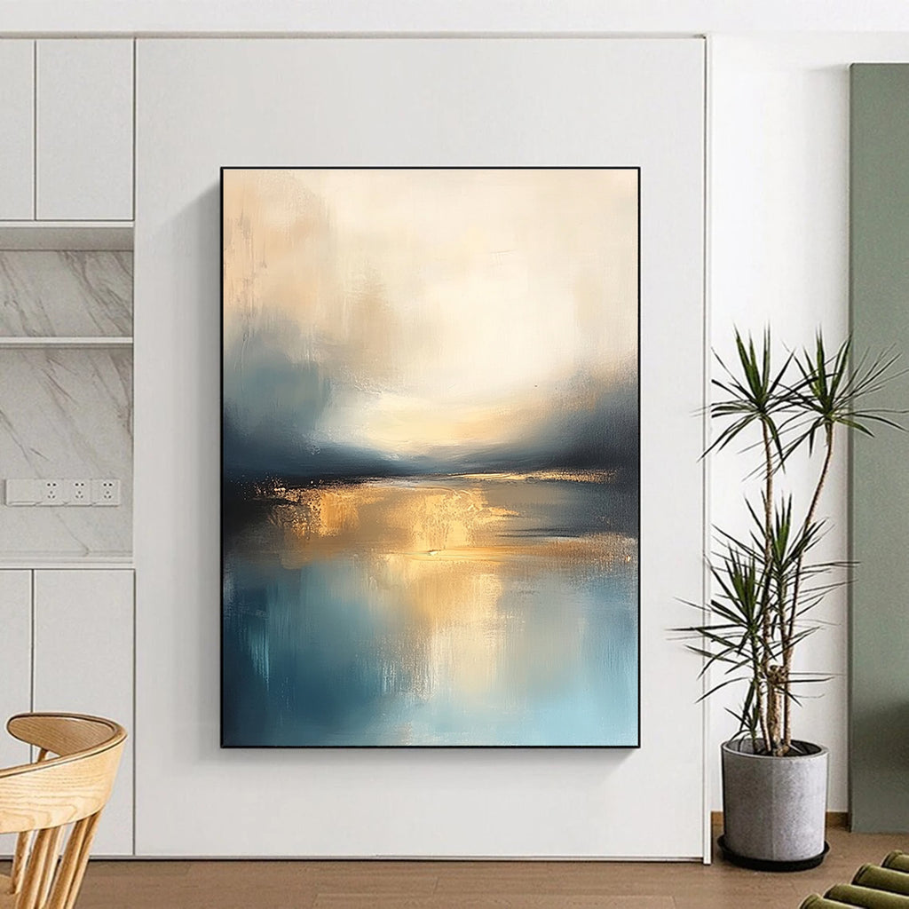 Large abstract painting featuring soft blue and gold tones with a calm sea reflections dramatic clouds and a tranquil sky.STSC103
