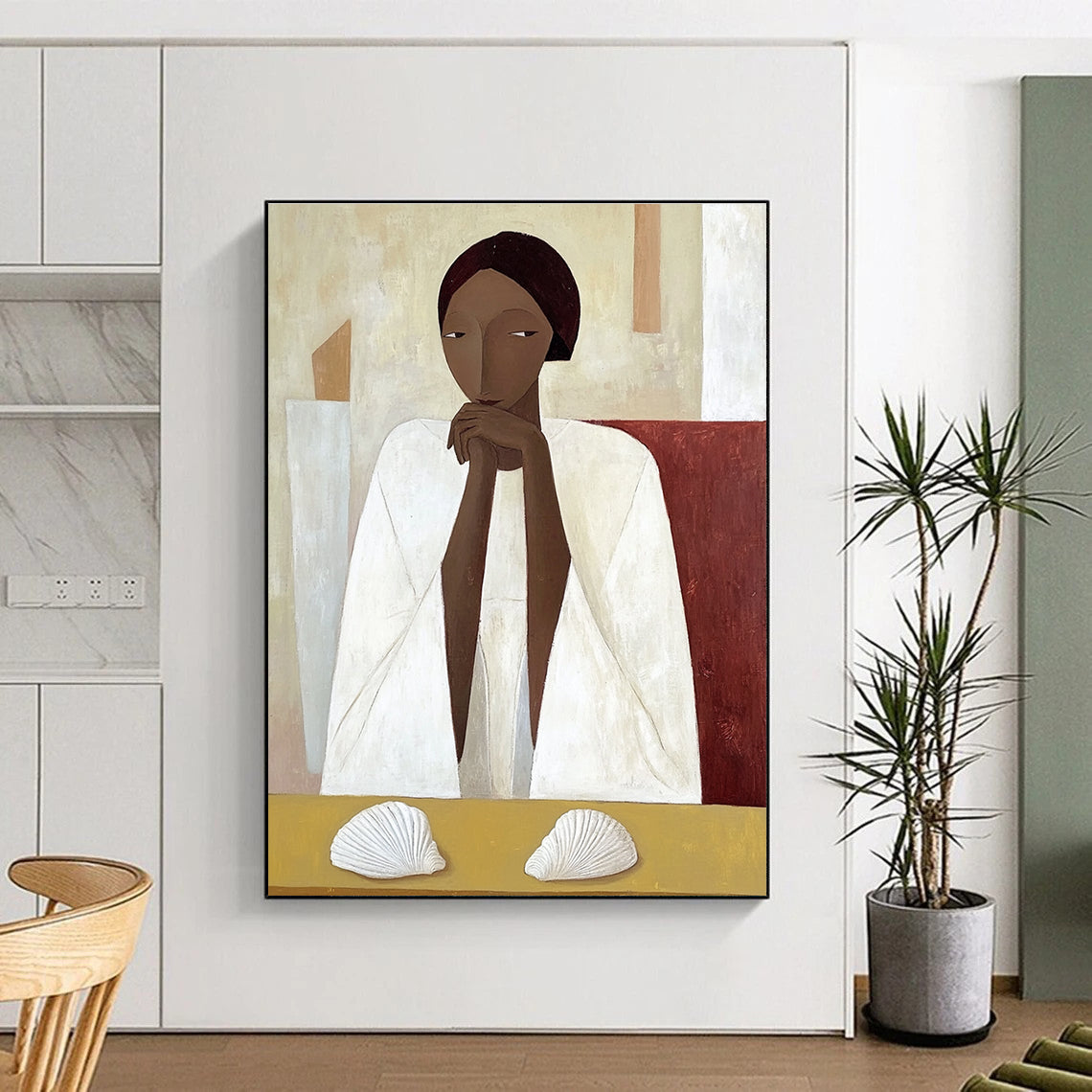 A large abstract painting featuring an African woman in a white cloak sitting on a yellow table with shells in daylight.STSC1115