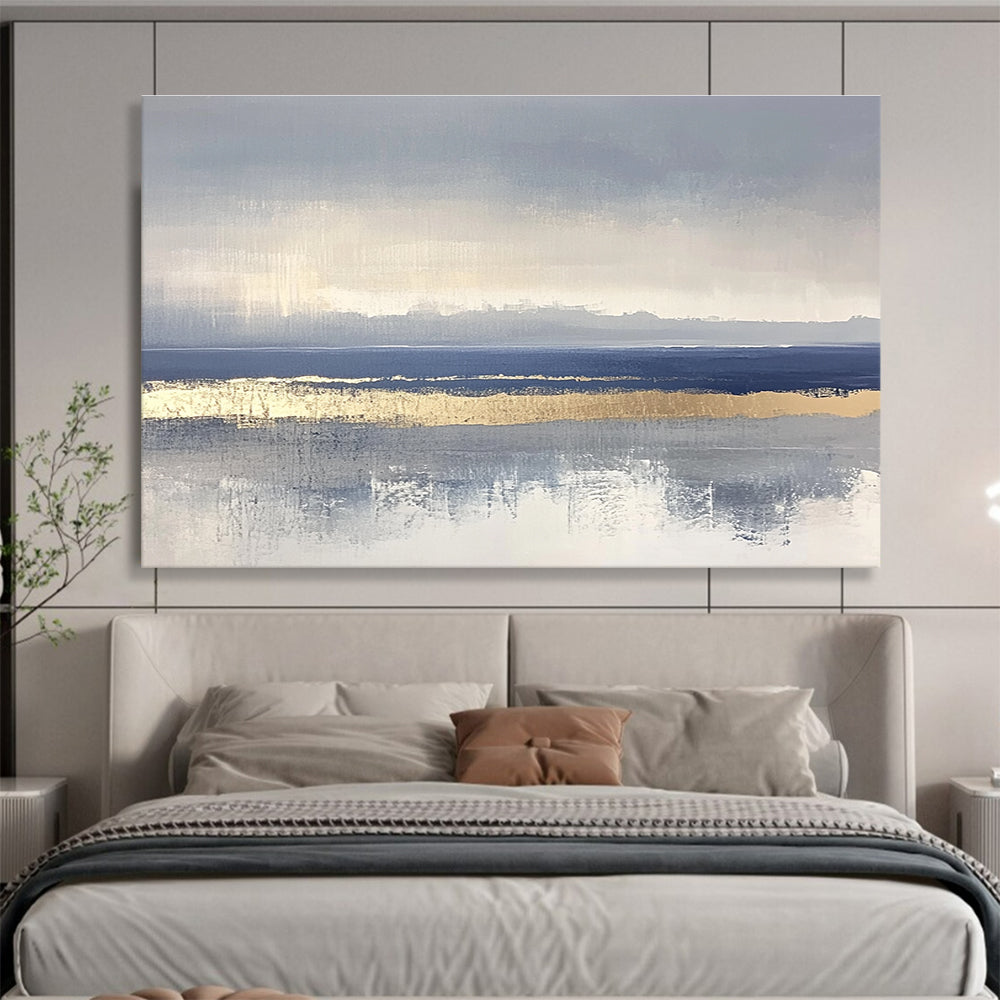 Large abstract painting featuring soft blue and gray tones with gold accents and visible brush strokes on a neutral background.SC038