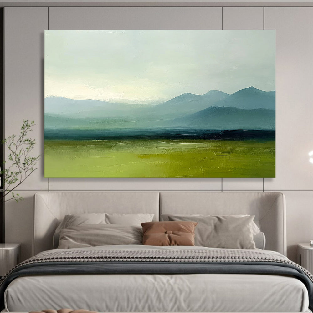 A large abstract oil painting depicting grassy plains and distant mountains in a minimalist style with a green and blue palette under a grey sky.SC409